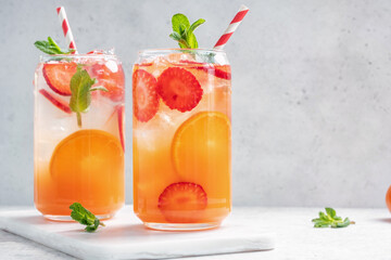 Delicious Orange lemonade with strawberries on grey table, space for text. Fresh summer cocktail