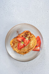 French toast with strawberries, maple syrup and sugar for breakfast