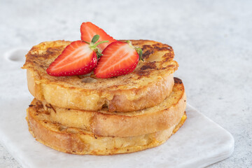 French toast with strawberries, maple syrup and sugar for breakfast