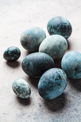 Easter eggs painted in trendy denim blue, gray background.