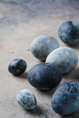 Easter eggs painted in trendy denim blue, gray background.