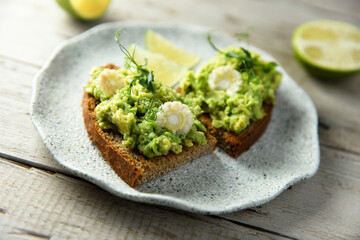 Homemade avocado toast with corn and lime