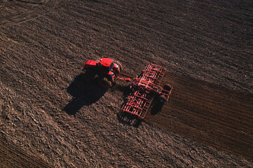 Tractor with cultivator plowing field. Tractor disk harrow on ploughing a soil. Sowing seed on...