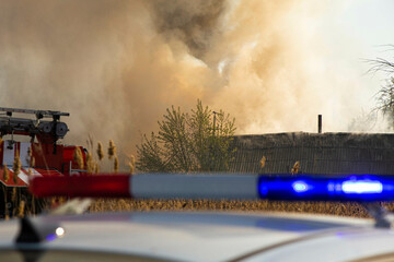 flashing beacon on the background of a fire and fire engines