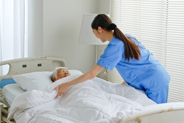 Young Asian woman, nurse, caregiver, carer of nursing home take care and cover a senior Asian woman...