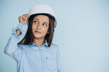 Child wearing white safety hat on blue background