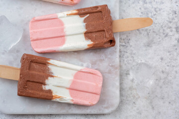 Neapolitan yogurt ice cream popsicle from vanilla, chocolate, and strawberry