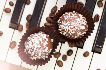 Chocolate round cakes with coconut on the piano