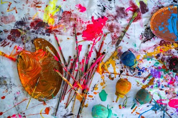 Top view of colorful color mixing on canvas background with paintbrush, paint palette and paint...