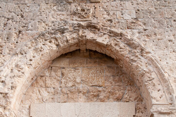 The arch and bullet-pocked stones of the Zion Gate to the Old City of Jerusalem, Israel.