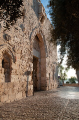 The arch and bullet-pocked stones of the Zion Gate to the Old City of Jerusalem, Israel.