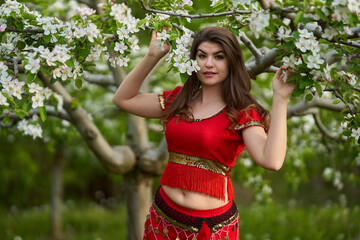 Young woman in apple orchard in indian costume