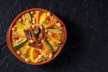 Couscous with meat and vegetables, festive Moroccan dinner, overhead shot with a place for text, on...