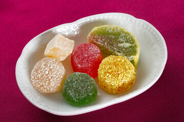 Close up view of multicolored sugary jelly candies on a bowl.