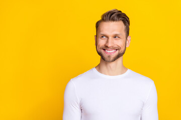 Portrait of glad funky person toothy smile look interested empty space isolated on yellow color background