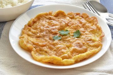 Thai omelette on a white plate.