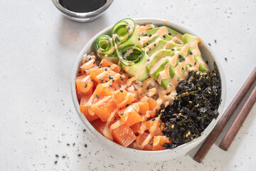 Hawaiian Salmon Poke Bowl with avocado, cucumber , rice and sesame seeds. Sushi bowl. Organic and healthy food.