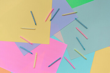 On a multi-colored background, a frame of candles. View from above. Place for text. Festive background. Postcard for the holiday. Birthday.