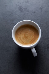 Cup of coffee on dark stone background. Close up. Copy space. 