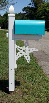 Aqua color mailbox with starfish theme in residential neighborhood. 