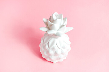 White pineapple tropical fruit on light pastel pink background.