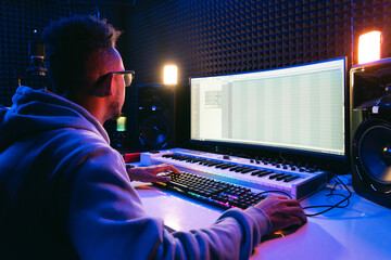 Producer, audio engineer uses a control panel and screen to record a track of a new album in a...