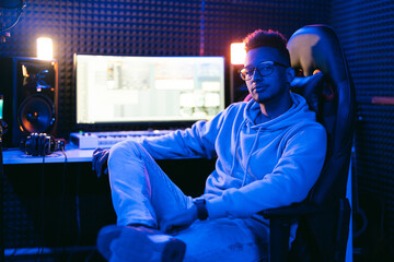 Producer, audio engineer uses a control panel and screen to record a track of a new album in a recording studio, in a soundproof room. Image producer, designer in working process
