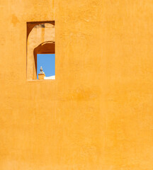 natural contrast in a yellow wall with a window and and ancient building