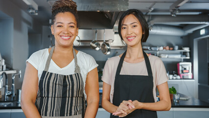 TV Cooking Show Kitchen with Two Master Chefs. Asian and Black Female Presenters Closing The Show...