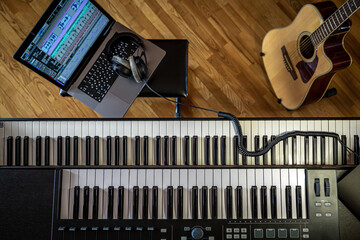 Piano keys, top view, musician's workplace with laptop.