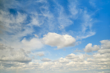 Fototapeta premium White cumulus clouds in the blue sky. Bright beautiful sky, copy space background