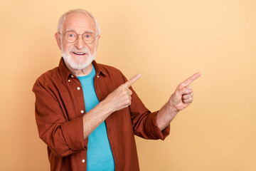 Photo of impressed old white hairdo man index empty space wear spectacles brown shirt isolated on...