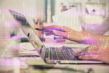 Multi exposure of woman hands typing on computer and financial graph hologram drawing. Stock market...