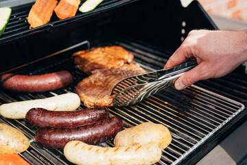 grilled sausages on the grill hand with 