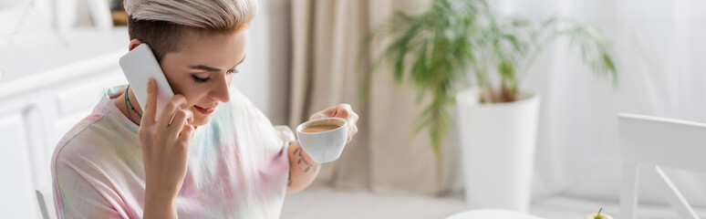 young woman with coffee cup talking on smartphone in morning, banner