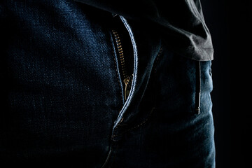 Unbuttoned men's trousers on a black background.