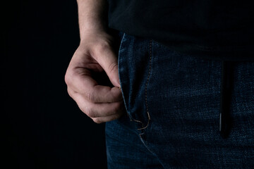 A man's hand unzips his pants in the dark.