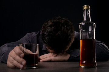 Drunk man passed out at the table while drinking alcohol.