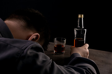 Drunk man passed out at the table while drinking alcohol.