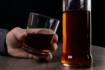 Glass cup with alcoholic drinks in hand.