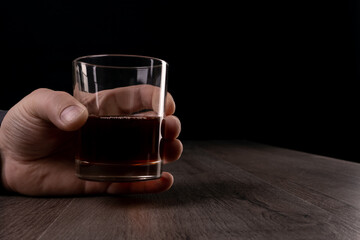 Glass cup with alcoholic drinks in hand.