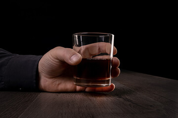 Glass cup with alcoholic drinks in hand.