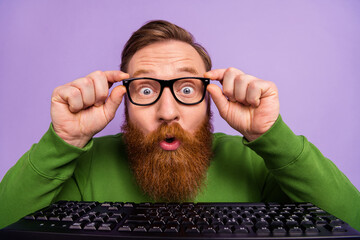 Portrait of young impressed it-specialist find a bug try to improve system isolated on purple color...