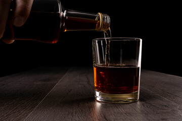 A man pours alcohol into a glass.