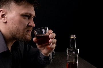Lonely man drinks alcohol in the dark.
