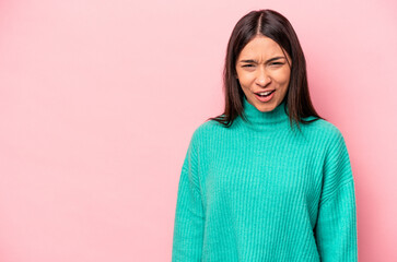 Fototapeta premium Young hispanic woman isolated on pink background shouting very angry, rage concept, frustrated.