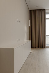 Part of room with an overhanging tube lamp with directional light on the furniture fittings near the curtain. Design, interior, details.