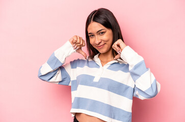 Young hispanic woman isolated on pink background feels proud and self confident, example to follow.