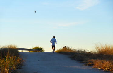 Runner on sunset. Run in sprint on footpath. Man sprinter on sunset. Male running for exercise....