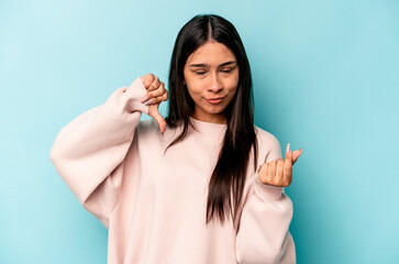 Young hispanic woman isolated on blue background showing that she has no money.